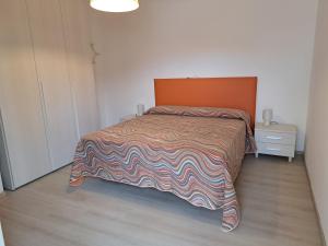 a bedroom with a large bed with an orange headboard at Appartamenti Oscar in Grado +24 photos