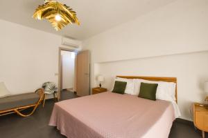 a bedroom with a large bed and a chandelier at Levante Sea View Apartment - Housea in Polignano a Mare