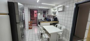 a small kitchen with a white table and white chairs at Melhor apto 3 suítes vista praia à beira mar, piscinas e estruturas in Parnamirim +58 photos