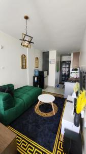 a living room with a green couch and a table at nook in Ongata Rongai 