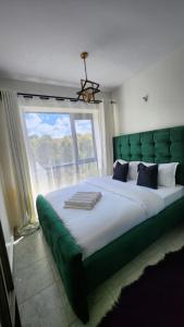 a bedroom with a large bed with a large window at nook in Ongata Rongai 