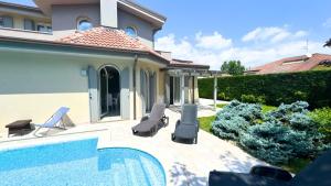 a house with a swimming pool next to a house at Villa singola con piscina Quinta Est in Rosolina