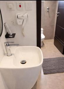 a white sink in a bathroom with a phone at Najd APARTMENTS in Al-ʿUla