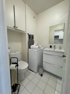 a white bathroom with a toilet and a sink at Cosy studio centre-ville & RER A in Saint-Germain-en-Laye