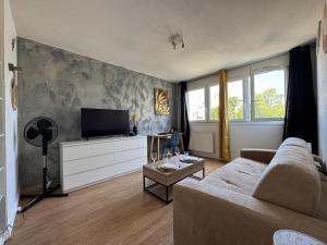a living room with a couch and a flat screen tv at Cosy studio centre-ville & RER A in Saint-Germain-en-Laye
