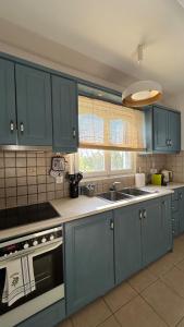 a kitchen with blue cabinets and a sink at Blue House Naxos in Naxos Chora