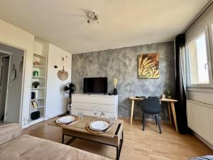 a living room with a bed and a table at Cosy studio centre-ville & RER A in Saint-Germain-en-Laye