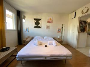 a bedroom with a bed with white sheets and towels at Cosy studio centre-ville & RER A in Saint-Germain-en-Laye +34 photos