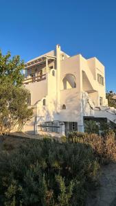 a large white building with trees in front of it at Blue House Naxos in Naxos Chora