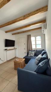 a living room with two blue couches and a tv at Blue House Naxos in Naxos Chora