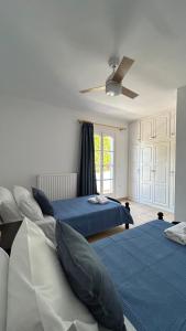 a bedroom with two beds and a ceiling fan at Blue House Naxos in Naxos Chora