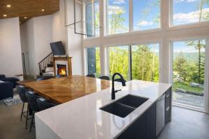 a kitchen with a sink and a counter with a fireplace at Havre du Mont in Saint Come