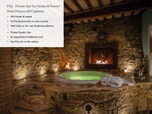 a stone bathroom with a tub with a fireplace at b&b BORGO CAPITANO COLLECTION Albergo diffuso, Village Experience - Centro Storico in San Quirico dʼOrcia