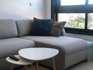 a living room with a couch and a white table at Refugio climático en Finisterre frente a la playa con vistas al mar!! in Fisterra