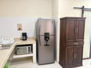 a refrigerator in a kitchen next to a microwave at Departamento Arena- Oasis del Mar in Progreso