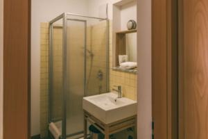 a bathroom with a sink and a glass shower at Rosi's Dorfwirtschaft in Rottenacker +41 photos