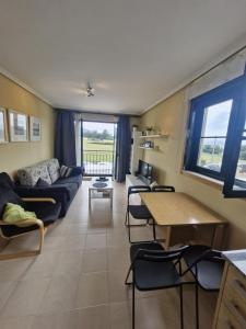 a living room with a couch and a table and chairs at Playa Reinante SPA in Barreiros