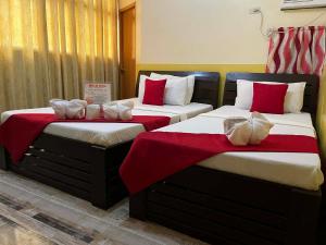 two beds sitting next to each other in a room at RTRoss Hotel in Masbate