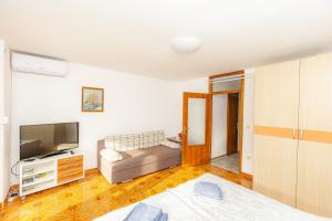 a living room with a couch and a television at Apartments M&M Portorož in Lucija