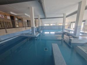 a swimming pool with blue water in a building at Playa Reinante SPA in Barreiros