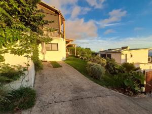 a driveway leading to a house in a yard at Entre mer et forêt in Les Avirons