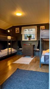 a room with two bunk beds and a desk and a window at Prinsgården B&B rum stugor in Mora