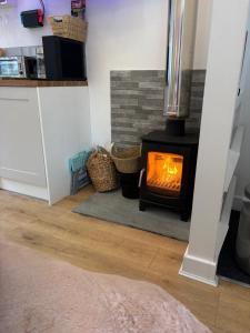 a living room with a wood stove in a room at Robyns Retreat in Brynsiencyn +22 photos