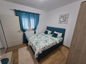 a bedroom with a bed with blue curtains at Apartment Angel in Kotor +21 photos