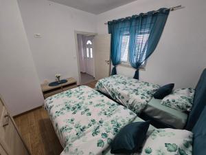 a bedroom with two beds and blue curtains at Apartment Angel in Kotor