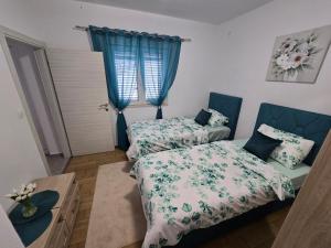 a bedroom with two beds and a table and a window at Apartment Angel in Kotor