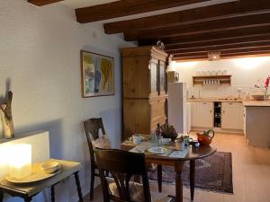 a dining room with a table and a kitchen at Gästezimmer Flora Hanauerland - Kunst & Natur nahe Straßburg in Kehl am Rhein