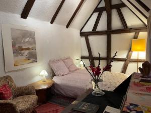 a bedroom with a bed and a couch and a table at Gästezimmer Flora Hanauerland - Kunst & Natur nahe Straßburg in Kehl am Rhein
