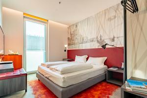 a bedroom with a large bed with a red headboard at Campanile Venice Mestre in Mestre +56 photos
