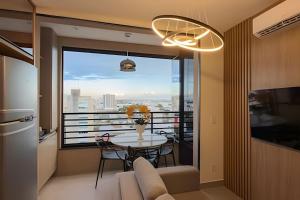 a living room with a table and a large window at Studios ZP in Uberlândia