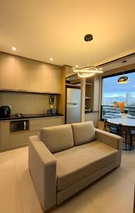 a living room with a couch in front of a kitchen at Studios ZP in Uberlândia
