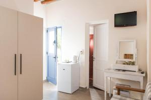 a white kitchen with a sink and a mirror at Aerides Boutique Rooms in Vathi