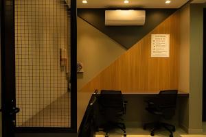 a conference room with two chairs and a desk at Studios ZP in Uberlândia +179 photos