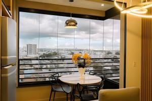 a room with a table and chairs and a large window at Studios ZP in Uberlândia