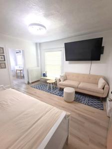 ein Wohnzimmer mit Sofa und Flachbildfernseher in der Unterkunft Snowdrop in Ames
