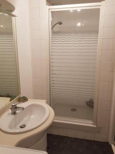 a white bathroom with a sink and a shower at Casino in Dieppe +11 photos