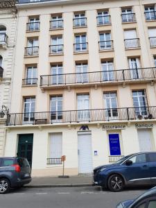 a building with balconies and cars parked in front of it at Casino in Dieppe