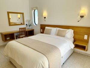 a bedroom with a large white bed and a mirror at Villa Tara Christina in Carvoeiro
