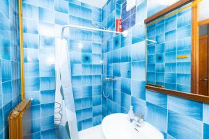 a blue tiled bathroom with a sink and a mirror at Apartments M&M Portorož in Lucija +37 photos