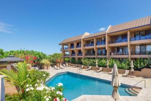 a hotel with a swimming pool in front of a building at Kona Pacific E629: Beautifully Remodeled condo! in Kailua-Kona