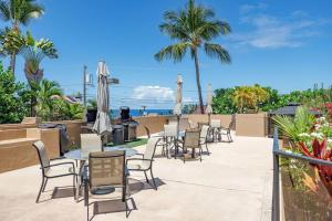 a row of tables and chairs with umbrellas at Kona Pacific E629: Beautifully Remodeled condo! in Kailua-Kona