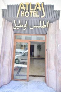 a sign for a hotel with a car in the window at Hôtel Atlas in Tangier