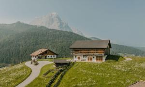 a building on a hill with a mountain in the background at Gutonhof in Selva di Val Gardena