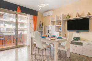 a dining room with a table with chairs and a flat screen tv at Apartamento en Cullera in Cullera