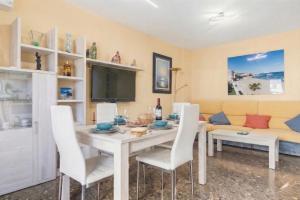 a dining room with a table and chairs and a couch at Apartamento en Cullera in Cullera