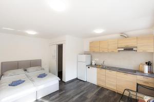 a bedroom with a white bed and a kitchen at Apartments M&M Portorož in Lucija